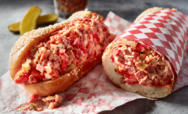 Sandwich roll cut in half filled with chopped pastrami.