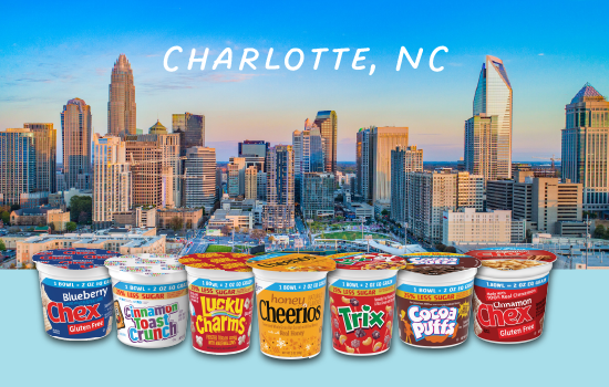 A vibrant skyline view of Charlotte, North Carolina at sunset with a clear blue sky. In the foreground, there is a row of seven colorful General Mills mini cereal cups lined up, including Blueberry Chex, Cinnamon Toast Crunch, Lucky Charms, Honey Nut Cheerios, Trix, Cocoa Puffs, and Cinnamon Chex. The text 