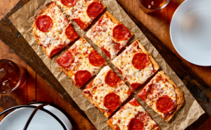 A pizza with different toppings on a wooden board.