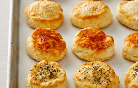 A variety of topped biscuits on a metal serving tray